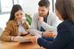 Couple meeting financial adviser for home investment contract